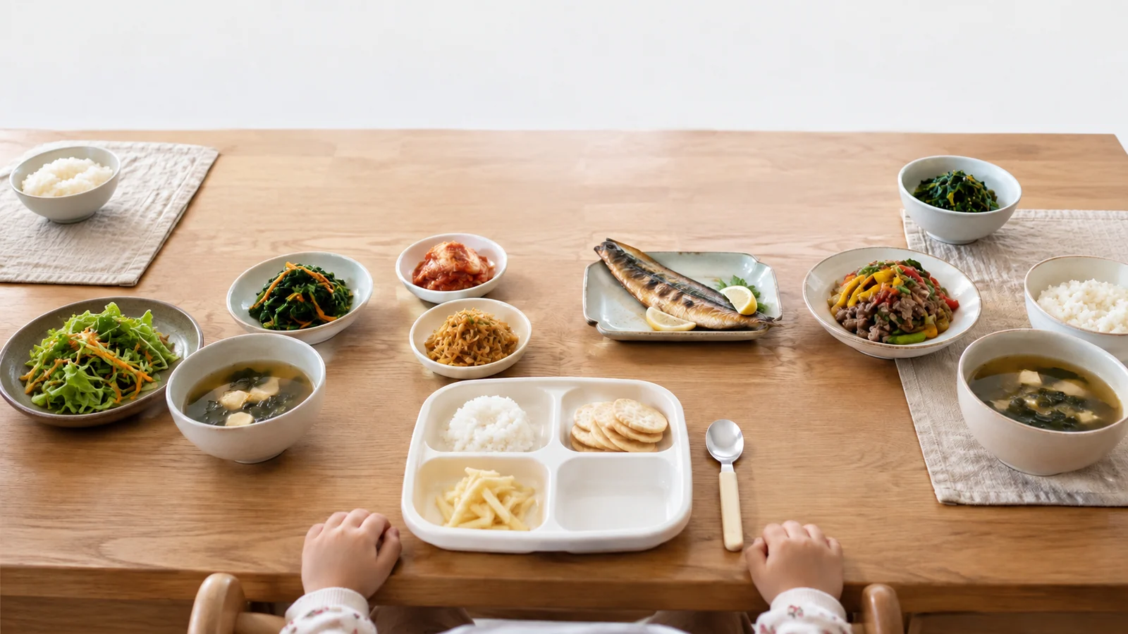 흰 식판의 칸마다 색이 비슷한 음식 몇 가지만 따로 담긴 가족 식탁 사진